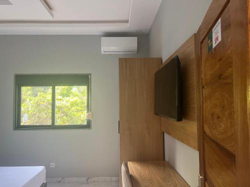 Zimmer mit einem TV, einem Bett und einem Fenster in der Unterkunft Canafistra Prestige Villa in Plaque