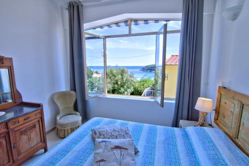 a bedroom with a bed and a large window at Casa Gabriella in Fetovaia