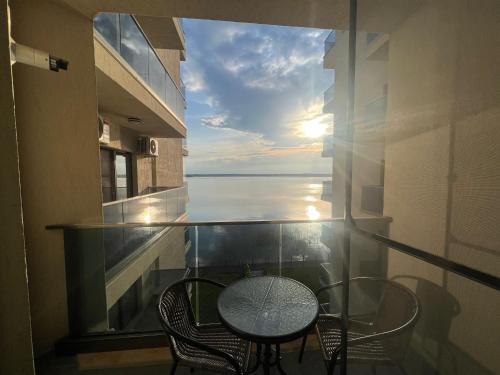 un balcone con tavolo e sedie e vista sull'oceano di Kitty Studio Sunset Lake a Mamaia