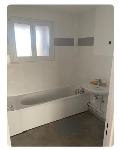 une salle de bain blanche avec une baignoire et un lavabo dans l'établissement Chaleureux et spacieux Cernay80, à Cernay