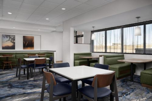 a waiting room with tables and chairs and windows at Fairfield Inn & Suites By Marriott Sioux Falls Airport in Sioux Falls