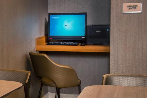 a computer on a shelf with a monitor and a keyboard at SpringHill Suites by Marriott Gainesville Haymarket in Gainesville