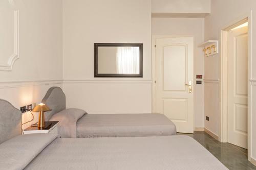 a bedroom with two beds and a mirror on the wall at The Port Residence in Livorno
