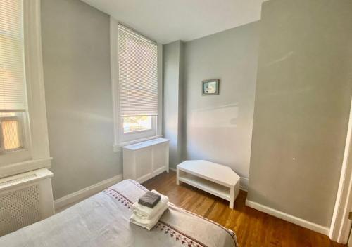 Habitación pequeña con cama y ventana en Clover 2900 - Apartment and Rooms with Private Bathroom near Washington Ave South Philly, en Filadelfia