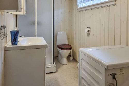 a white bathroom with a toilet and a sink at Feriehus - Arendal ved sjøen in Arendal