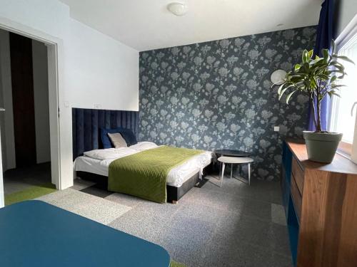 um quarto com uma cama e um vaso de plantas em Komarowo77 