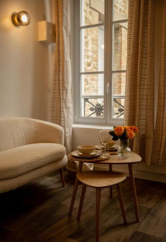 - un salon avec une table, une chaise et une fenêtre dans l'établissement Studio la halte ducale #3, à Charleville-Mézières