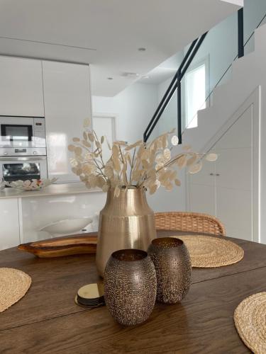 a table with a vase and two cups on it at Moderne ny villa in San Pedro del Pinatar