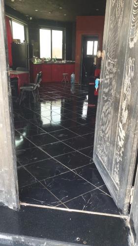 an open door to a room with a black tile floor at Villa Mostafa Sadek, Swimming pool, Tennis & Squash - Borg ElArab Airport Alexandria in Borg El Arab