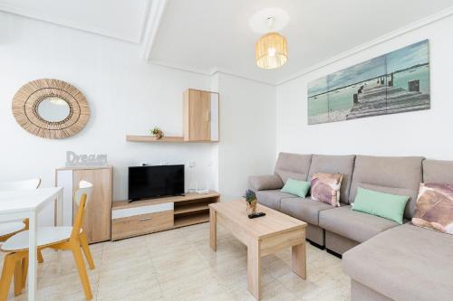 een woonkamer met een bank en een tafel bij Bungalow Aguas Nuevas Sunrise in Torrevieja