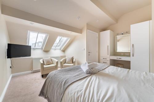 a bedroom with a white bed and a tv at Ralston in Ambleside
