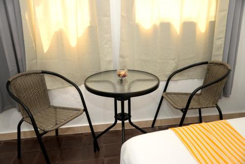 two chairs and a glass table in a room at Hostal Mi Rincón in Santo Domingo