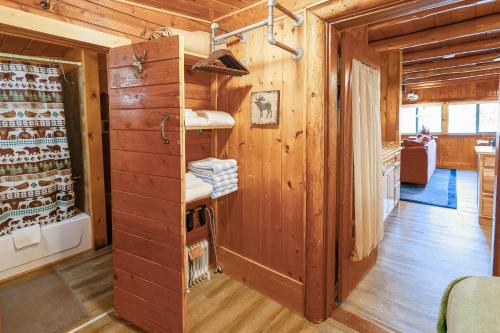 a room with wooden walls and a wooden floor with a bathroom at Paradise on the Lake in Vallecito