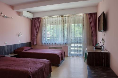 a hotel room with two beds and a window at Family Hotel Kipra in Kipra