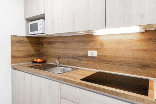 a kitchen with a sink and a microwave at Apartment Tina in Podčetrtek
