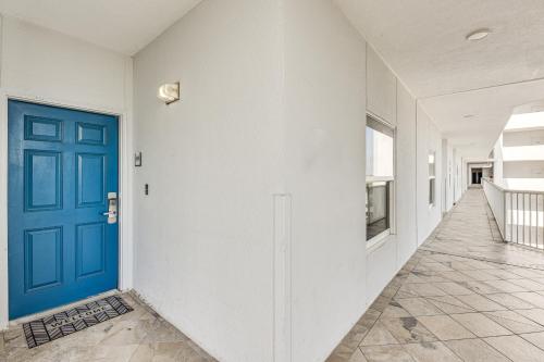a hallway with a blue door and white walls at Oceanfront Destin Condo with Pool and Beach Access in Destin