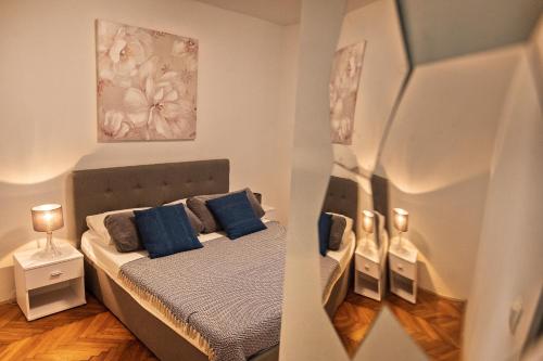 a small bedroom with a bed with blue pillows at Apartment Pape in Split