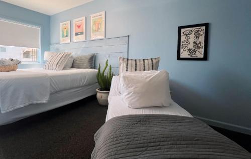 a blue bedroom with two beds and a plant at Quality Lodge in Sandusky