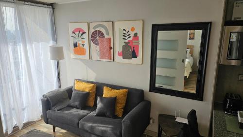 a living room with a couch and a mirror at Best Apartment Rental Estación Central in Santiago