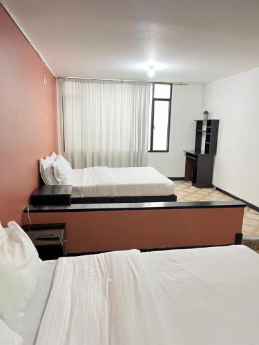 um quarto de hotel com duas camas e uma televisão em Way Maker 1 em Bogotá