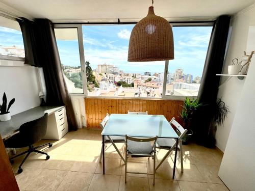 - une table et des chaises dans une chambre avec fenêtre dans l'établissement Cozy Fuengirola apartment with sea view & pool, à Fuengirola