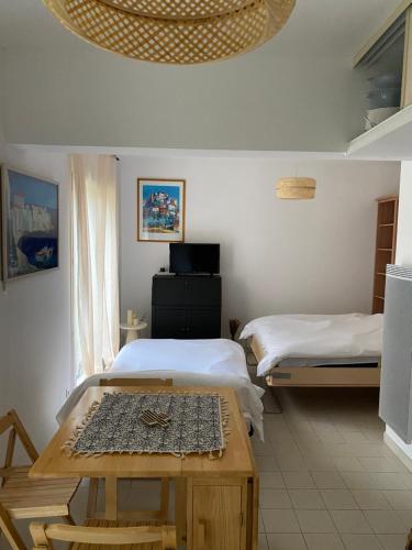 ein Zimmer mit zwei Betten und einem Tisch darin in der Unterkunft Charmant Studio de 28 M2 in Brando