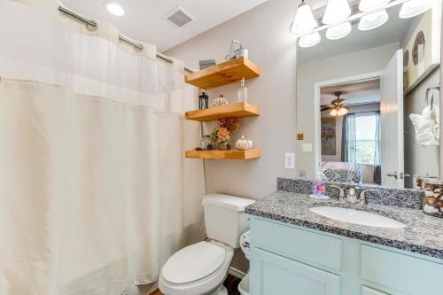 a bathroom with a toilet and a sink and a mirror at Mtn-View Gem with Hot Tub Access Branson Condo in Branson