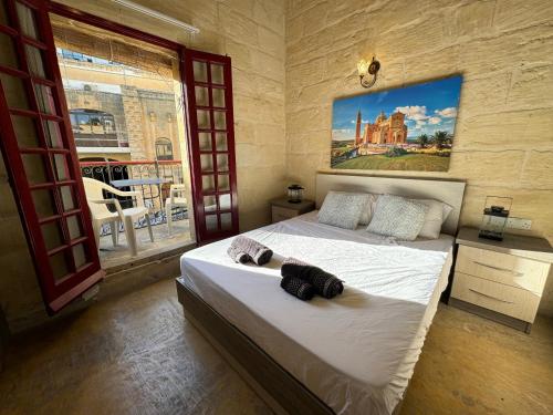 1 dormitorio con 2 camas y un cuadro en la pared en The Nest 148 Townhouse, en Għajn il-Kbira