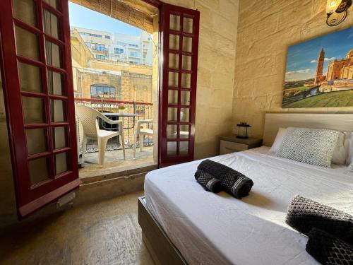 1 dormitorio con cama y ventana grande en The Nest 148 Townhouse, en Għajn il-Kbira
