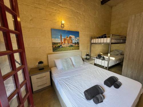 sypialnia z białym łóżkiem i 2 łóżkami piętrowymi w obiekcie The Nest 148 Townhouse w mieście Għajn il-Kbira