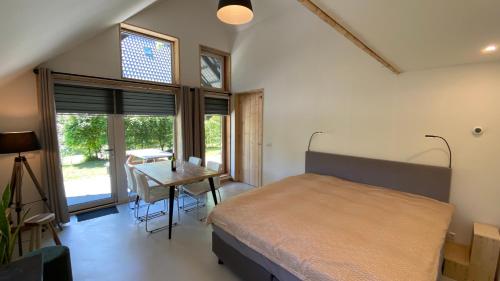 1 dormitorio con cama, escritorio y mesa en JouwvakantiehuisNL - Accommodatie Drentsche Aa, en Vries