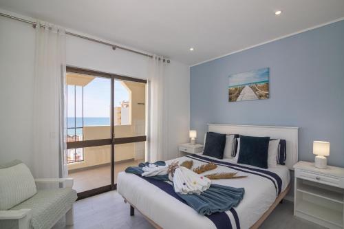una camera da letto con un letto con vista sull'oceano di Cruzeiro - Silhueta Citadina a Portimão