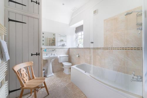 a bathroom with a tub and a toilet and a sink at Riverside House in Elterwater