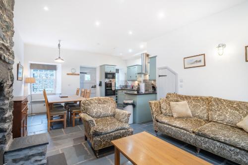 a living room with a couch and chairs and a table at Riverside House in Elterwater