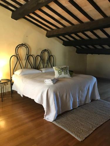 een groot bed in een kamer met een houten vloer bij La Casa di Helena in Stroncone