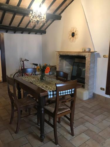 uma sala de jantar com uma mesa e uma lareira em La Casa di Helena em Stroncone