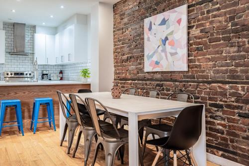 a dining room with a brick wall and a table and chairs at Vibrant Le Plateau Escape for Groups Near Metro in Montréal