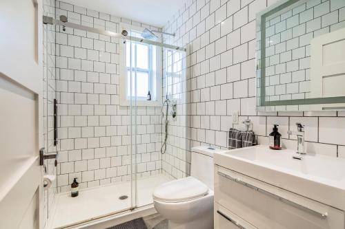 La salle de bains blanche est pourvue de toilettes et d'un lavabo. dans l'établissement Ideal Group Stay in Charming Le Plateau Near Metro, à Montréal