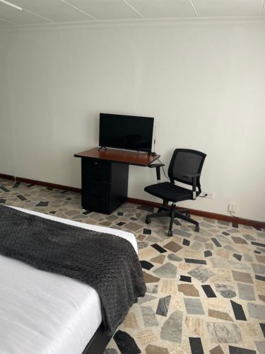 1 dormitorio con escritorio, silla y piano en Way Maker sede 2, en Bogotá