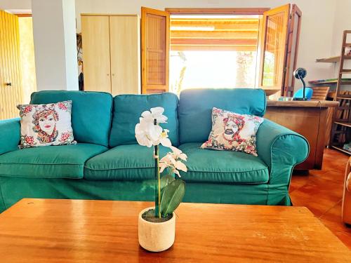 um sofá verde numa sala de estar com uma mesa em Casa Margherita Cefalù - Villa con accesso privato al mare em Cefalù