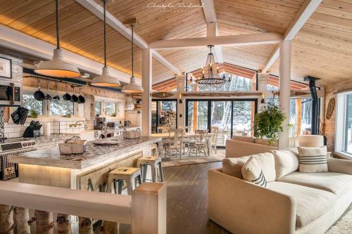 a kitchen and living room with a couch and a table at Chalet Makabane -Spa- foyer - billard - Slow life in La Malbaie