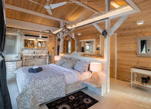 a bedroom with a bed in a log cabin at Chalet Makabane -Spa- foyer - billard - Slow life in La Malbaie