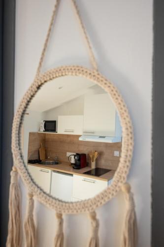 un miroir avec un cadre en corde dans une cuisine dans l'établissement BLD-Location, à Le Gond-Pontouvre