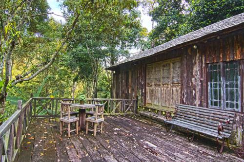 a wooden deck with a table and a bench at Fig Tree Hills Resort (花果山度假村) in Bayan Lepas