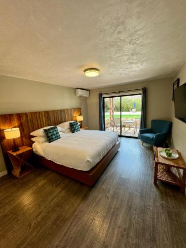 a bedroom with a bed and a chair and a window at Hidden Valley Inn in Carmel Valley
