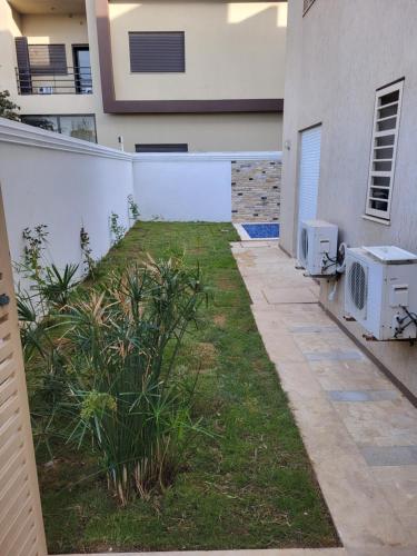 a backyard of a house with a fence and a microwave at New appartement with à private pool in La Marsa