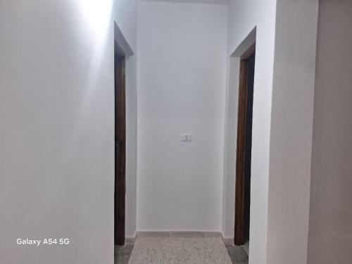 a hallway with two doors in a white wall at Diar khayri in Mezraya