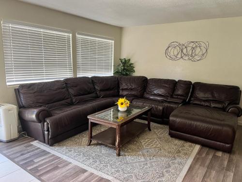 a living room with a leather couch and a coffee table at Peaceful 2bed,1bath condo with free parking all yours to enjoy in Fresno