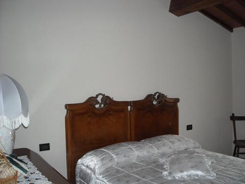 a bedroom with a bed with a wooden head board at Bed&Breakfast Pianeta Benessere in Pistoia