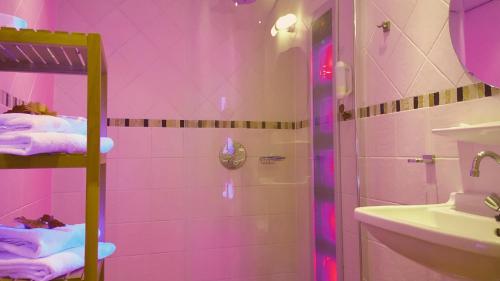 a pink bathroom with a shower and a sink at Hotel Restaurant Dolores in Hollum